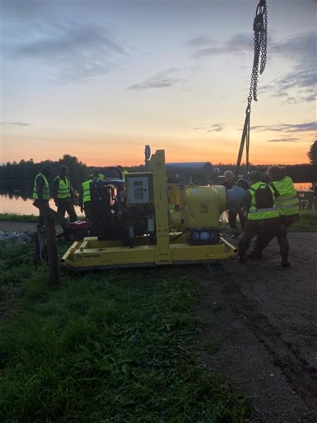 Personer arbetar med en vattenpump.